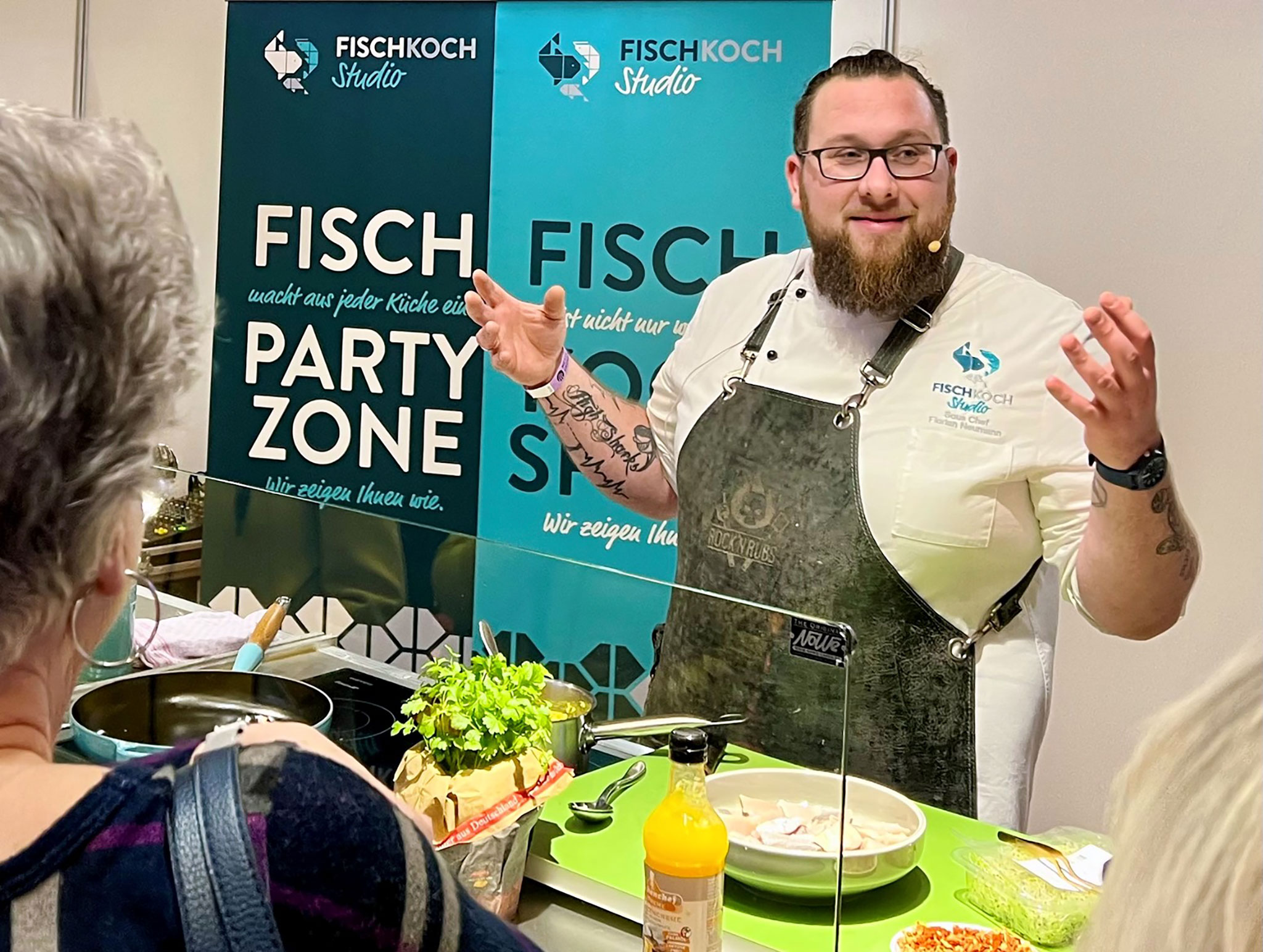 Der Koch der Fischkochshow auf einer vergangenen Fischparty hinter seinem Küchentresen